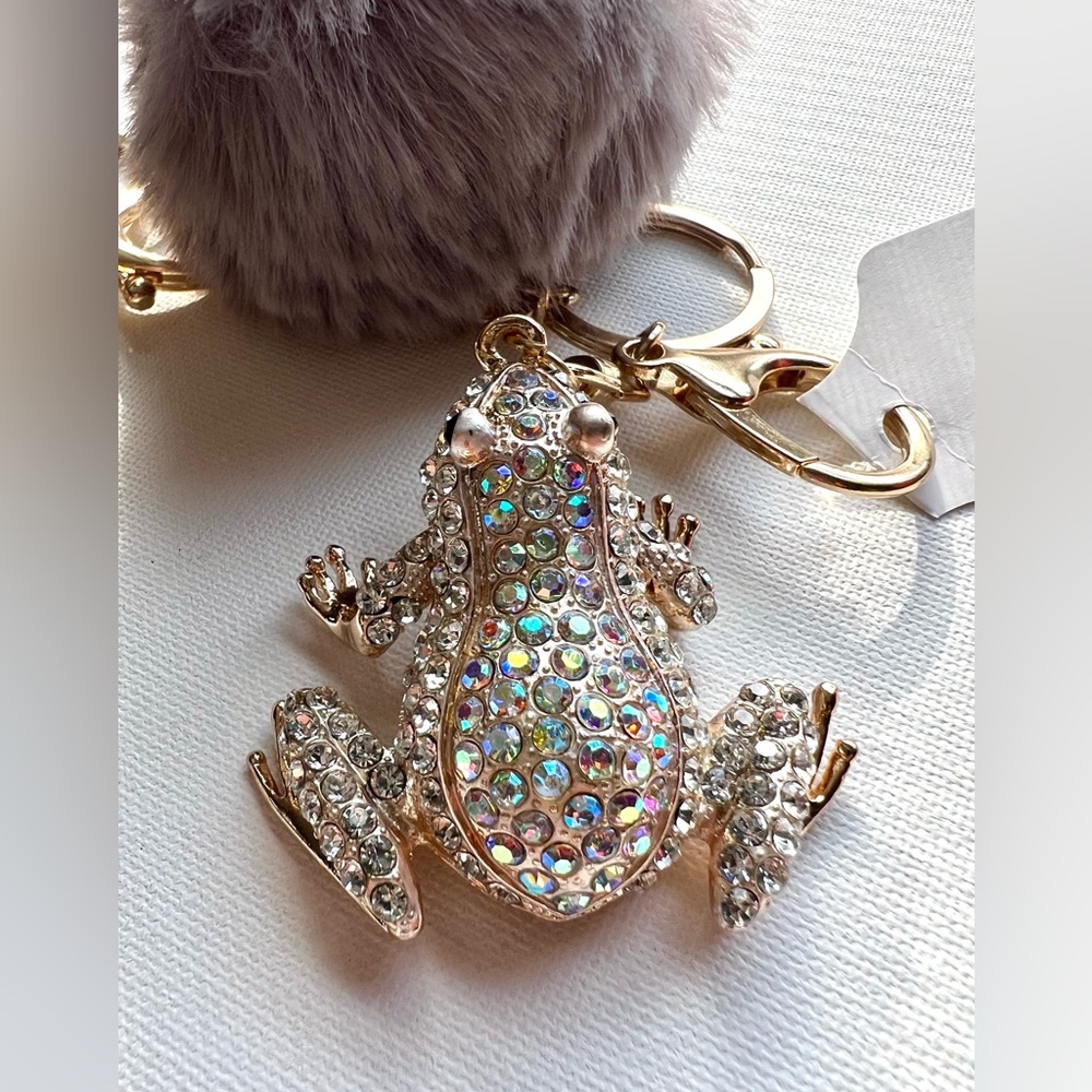 Llavero de rana con cristales multicolor y pompón color gris. BLANCO.